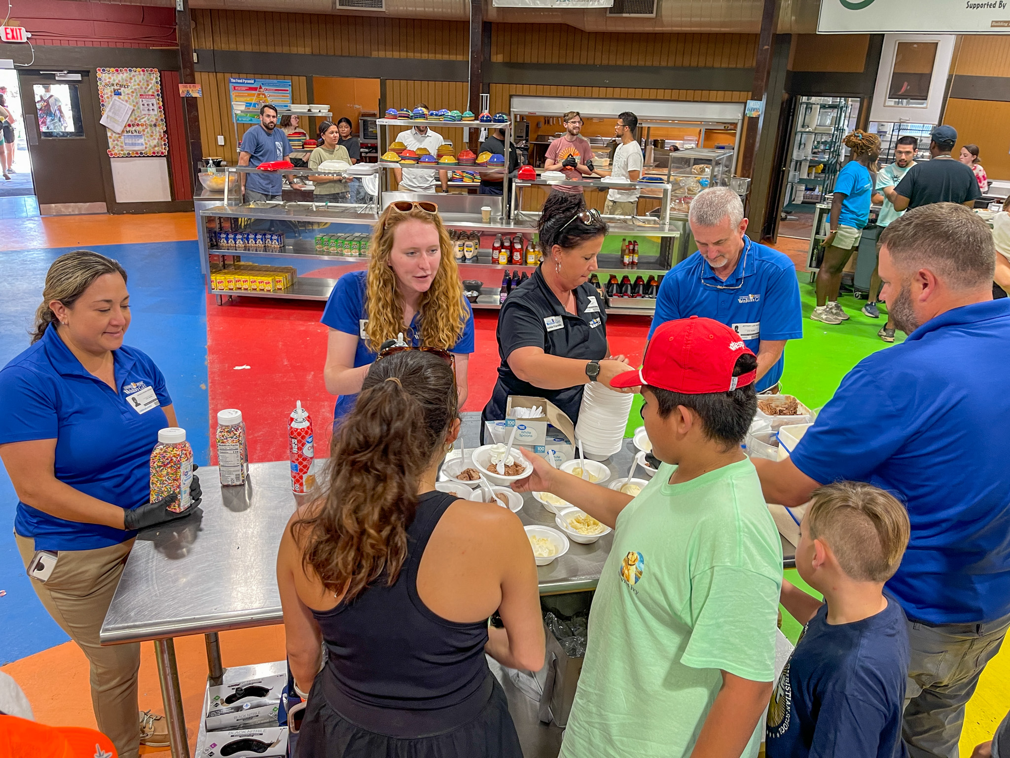Walton Gas employees, from left, Patricia Greenway, Morgan Spivey, Ashlie Franklin, Jeff Paul and Pete Ervin serve ice cream to ESP campers at Camp Twin Lakes.